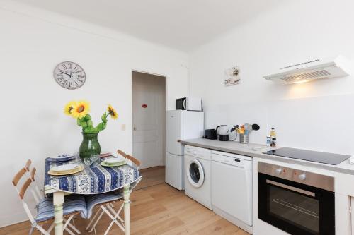 une cuisine avec une table avec un vase de fleurs dessus dans l'établissement IMMOGROOM - 5 min from beaches - Suquet - AC, à Cannes