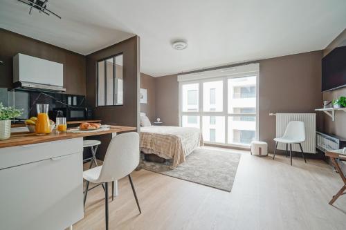 - une chambre avec un lit et un bureau avec des chaises dans l'établissement Proche Métro 5 et tram, parking, résidence neuve, à Bobigny