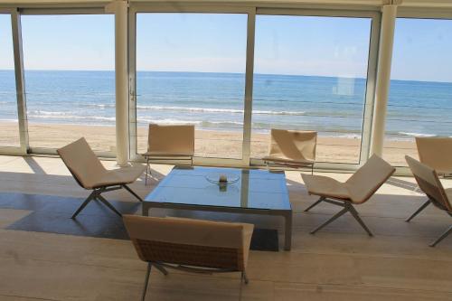 a room with a table and chairs and the beach at Hotel Amyclae in Sperlonga
