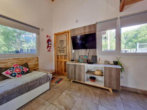 a bedroom with a bed and a flat screen tv at Claro del Bosque in San Carlos de Bariloche