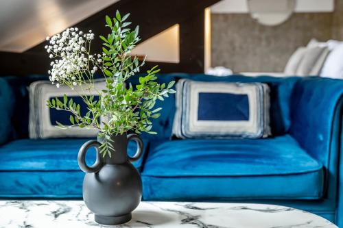 un canapé bleu avec un vase et des fleurs sur une table dans l'établissement 61#Opera#Studio#Louvre#AC, à Paris