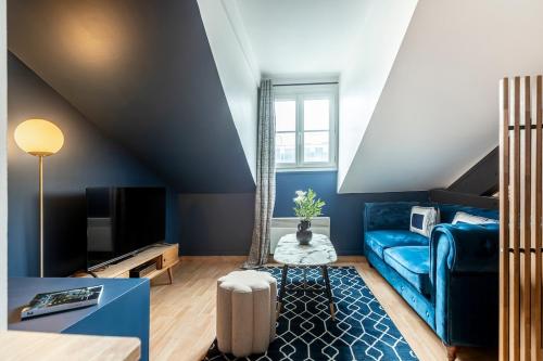 un salon avec un canapé bleu et une télévision dans l'établissement 61#Opera#Studio#Louvre#AC, à Paris