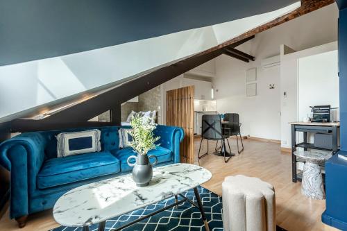un salon avec un canapé bleu et une table dans l'établissement 61#Opera#Studio#Louvre#AC, à Paris