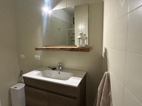 a bathroom with a sink and a mirror at Appartamento Valentina piscina e vista lago in Riva di Solto