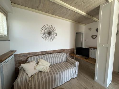 a living room with a couch and a television at Appartamento Valentina piscina e vista lago in Riva di Solto