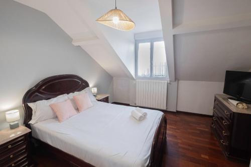 una camera da letto con un letto bianco e una televisione di Le Vitry - Calme, terrasse, proche Paris a Vitry-sur-Seine