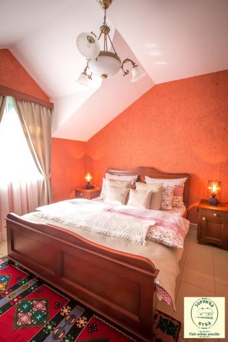 a bedroom with a large bed with orange walls at Zornića Kuća in Ba°evac