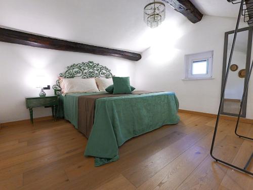 a bedroom with a bed with a green blanket on it at Angiolina's Farm in Levanto