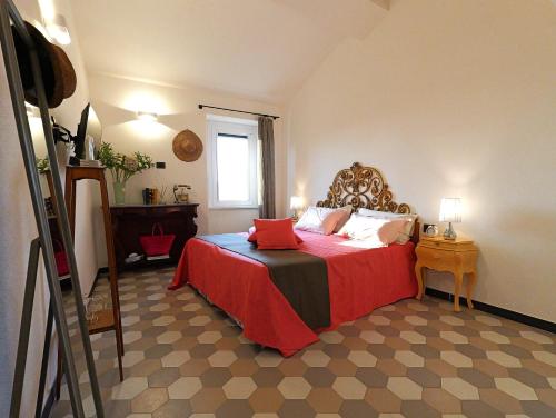 a bedroom with a bed with a red blanket and a window at Angiolina's Farm in Levanto