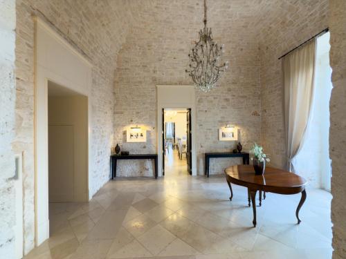 a dining room with a table and a brick wall at Relais Il Santissimo in Turi