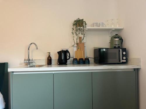 a kitchen counter with a microwave and a sink at The Briarcroft in Goole