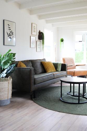 a living room with a couch and a table at Cozy cottage in the heart of the Veluwe in Putten