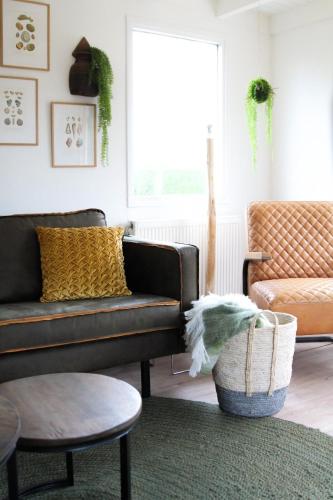 a living room with a couch and a table at Cozy cottage in the heart of the Veluwe in Putten