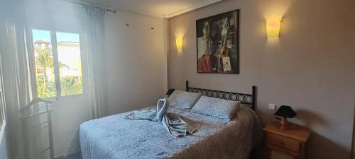 Un dormitorio con una cama con sábanas azules y una ventana. en Charming Apartment with Pool in Puerto Rey 60 m², en Media Legua