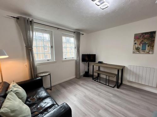 a living room with a couch and a desk at Causewayside Free parking in Edinburgh