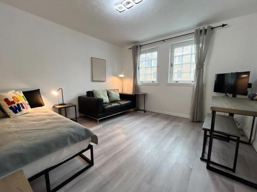 a bedroom with a bed and a couch and a television at Causewayside Free parking in Edinburgh