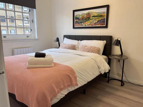a bedroom with a large bed with a orange blanket at Causewayside Free parking in Edinburgh