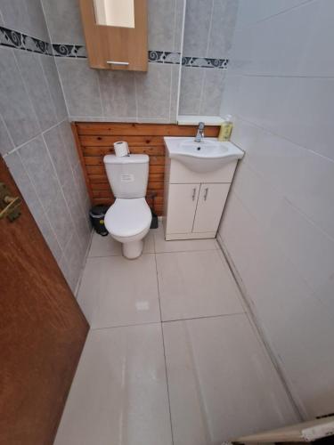 a small bathroom with a toilet and a sink at Cosy rooms in London in London