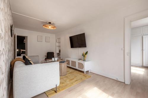 un salon avec un canapé et une télévision dans l'établissement 52#Opera#Grands Boulevards#Paris02, à Paris