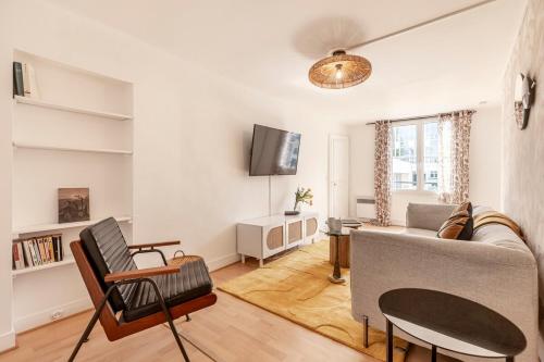 un salon avec un canapé et une télévision dans l'établissement 52#Opera#Grands Boulevards#Paris02, à Paris