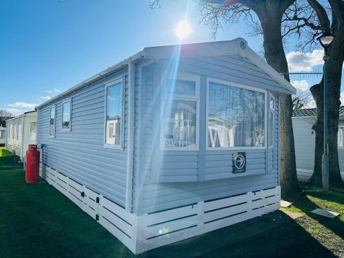 a white tiny house parked next to a tree at Island Escape Sandown in Sandown
