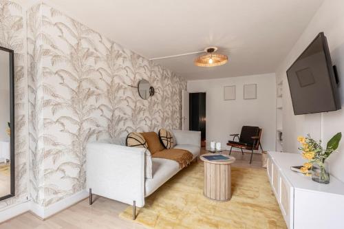 un salon avec un canapé et une télévision dans l'établissement 52#Opera#Grands Boulevards#Paris02, à Paris