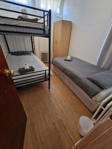 a bedroom with two bunk beds and a wooden floor at Cosy rooms in London in London