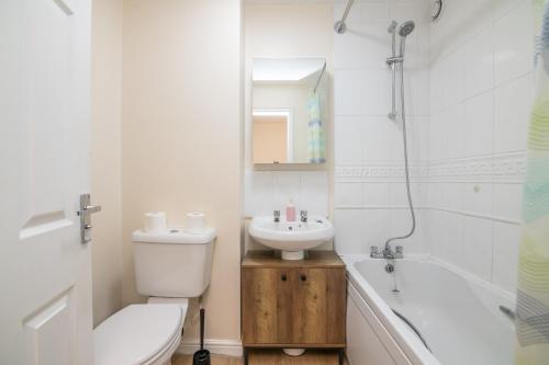 a bathroom with a sink and a toilet and a bath tub at Lovely refurbed 4 bed house in Black Country in Tipton