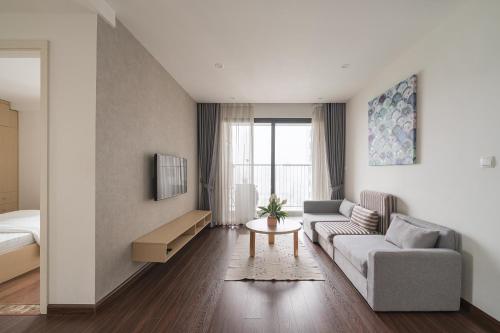 a living room with a couch and a bed at HN ETH Vinhomes D'capitale Resident - Tran Duy Hung St in Hanoi
