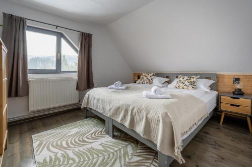 a bedroom with a bed and a window at Mountain Air Lodge in Izvoru Mureşului