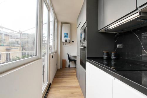 a kitchen with a black counter top and a window at Luxury loft Cassia in Rome