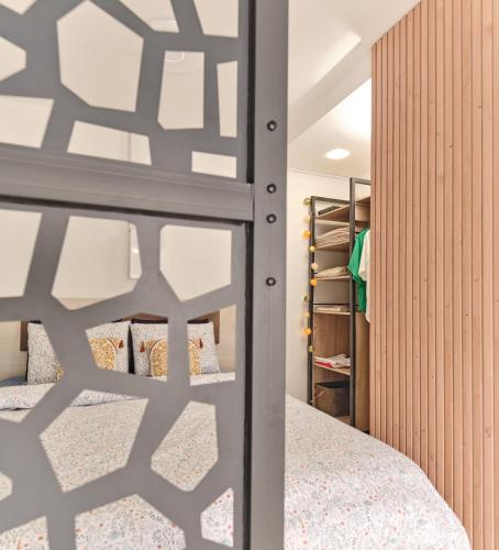 une chambre avec un lit et un mur en bois dans l'établissement ICÉ'O, Les pieds dans l'eau, à Saint-Hilaire-de-Riez