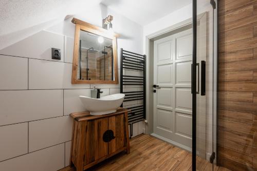 a bathroom with a sink and a mirror at Mountain Air Lodge in Izvoru Mureşului