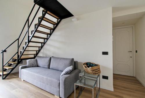 a living room with a couch and a staircase at Luxury loft Cassia in Rome