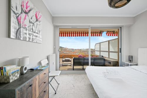 une chambre avec un lit et une vue sur un balcon dans l'établissement 'L'Alicante proche' gare, terrasse, vue mer, à Menton