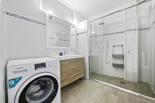 une salle de bain avec une machine à laver et un lavabo dans l'établissement 'L'Alicante proche' gare, terrasse, vue mer, à Menton