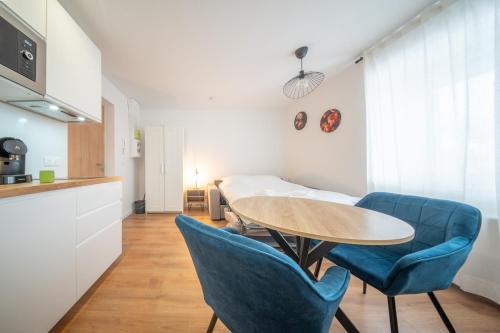 une chambre avec une table et deux chaises bleues dans l'établissement Super Appartement Near Basel 6, à Saint-Louis