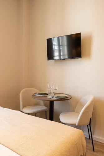 une pièce avec une table et deux chaises et une télévision dans l'établissement Studio calme et paisible aux porte de Paris - III, à Le Pré-Saint-Gervais
