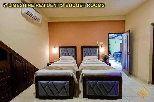 two beds in a room with orange walls at Limeshine - Airport Transit Hotels & Residences in Katunayake