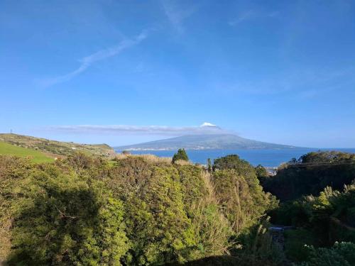 a view of the ocean and a mountain in the distance at Casinha Branca in Horta