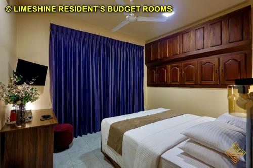 a bedroom with a bed and a blue curtain at Limeshine - Airport Transit Hotels & Residences in Katunayake