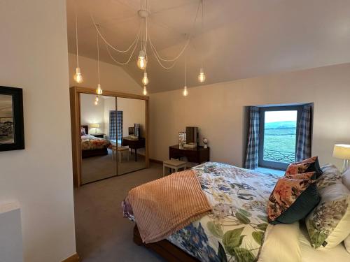 a bedroom with a bed and a large mirror at Lower Carhullan in Penrith
