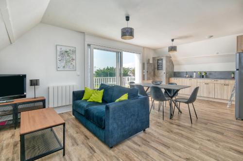 un salon avec un canapé bleu et une table dans l'établissement Bel appartement - 2min plage, à La Turballe