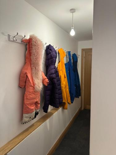 a hallway with several coats hanging on a wall at Lower Carhullan in Penrith