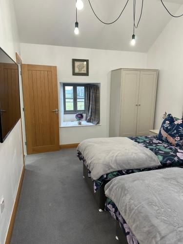 a bedroom with two beds and a window at Lower Carhullan in Penrith