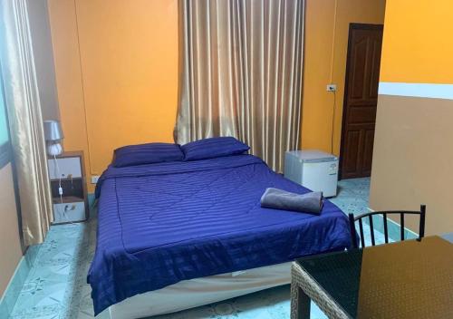 a bedroom with a bed with purple sheets and a table at Le Saint Germain in Hua Hin