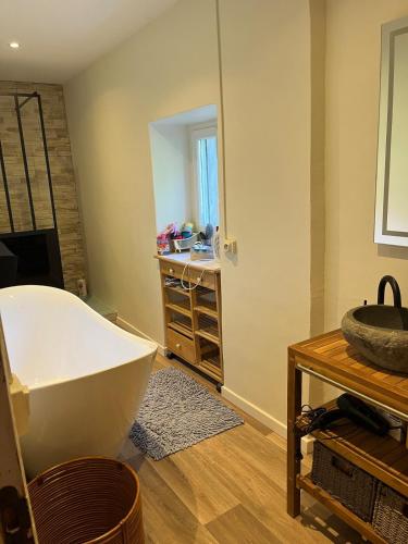 une salle de bain avec une baignoire et un miroir dans l'établissement Jolie maison des Cévennes, à Aumessas