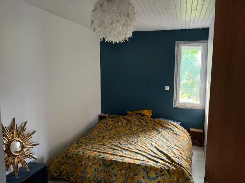 une chambre avec un lit et un mur bleu dans l'établissement Jolie maison des Cévennes, à Aumessas