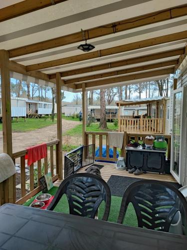 - une terrasse couverte avec des chaises et un barbecue dans l'établissement MOBIL - HOME 2 6p Bois de Bayadene, à Piriac-sur-Mer