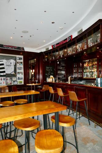 a restaurant with wooden tables and chairs and a bar at Hotel Amadeus Frankfurt in Frankfurt/Main